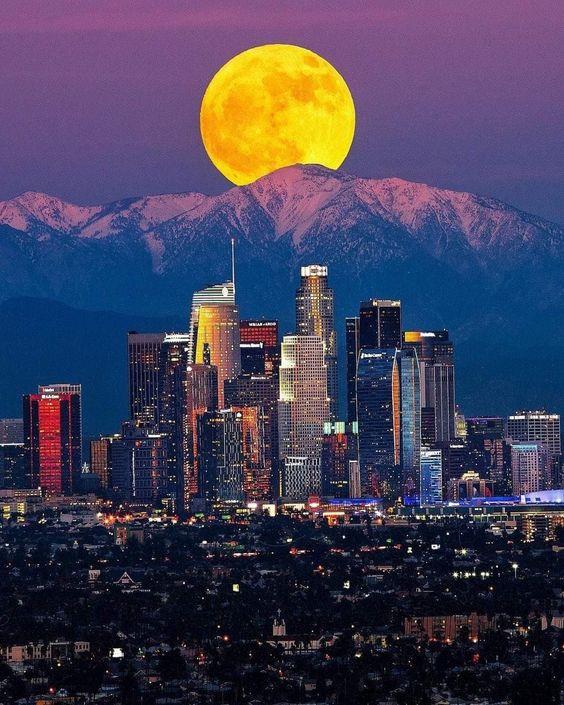 Capturing the enchanting magic of a moonrise over the Los Angeles skyline against the backdrop of Skyline Mountain.