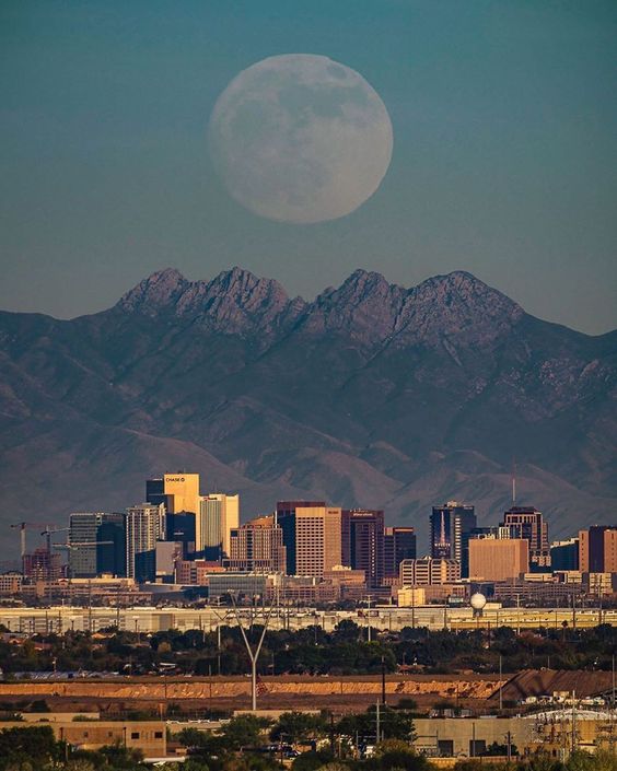 Capturing the enchanting magic of a moonrise over the Los Angeles skyline against the backdrop of Skyline Mountain.